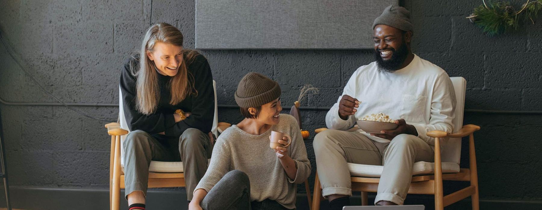 friends sit together around an open laptop